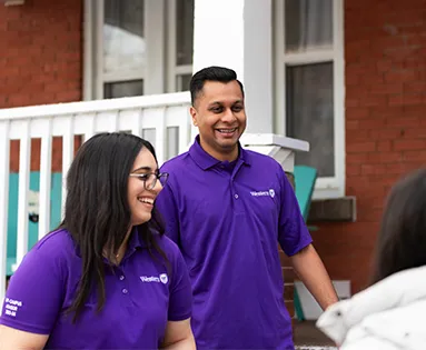 Two Off-Campus Advisors standing in front of a house
