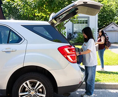 Two students unloading a car